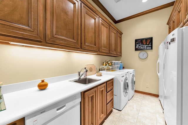 laundry room featuring ornamental molding, sink, light tile patterned floors, washer and clothes dryer, and cabinets