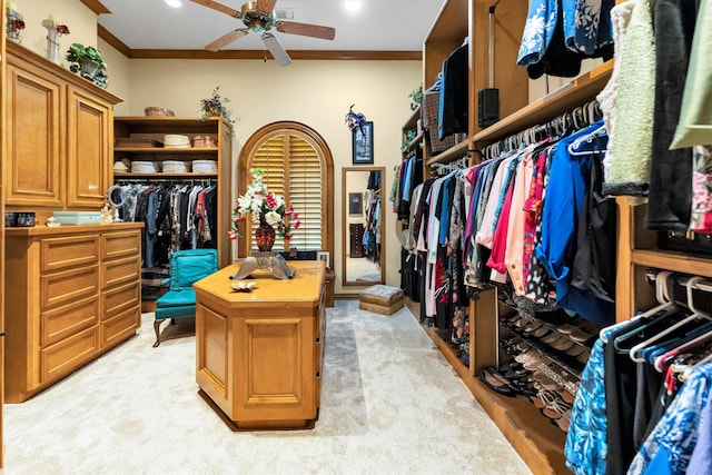 walk in closet with light carpet and ceiling fan