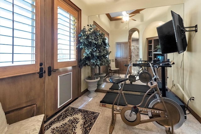 exercise room featuring ceiling fan, crown molding, and light carpet