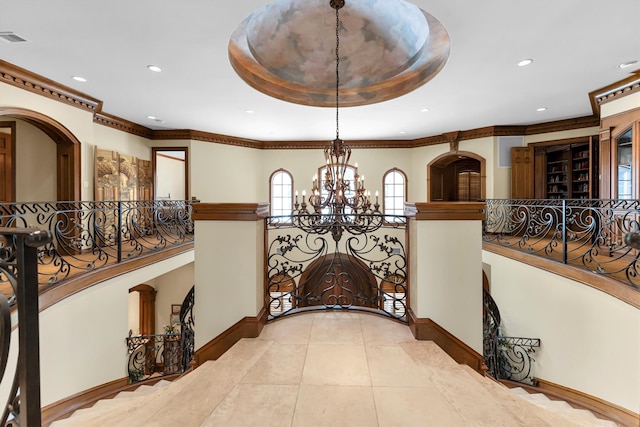 hallway featuring crown molding, light tile patterned flooring, and a chandelier