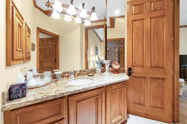 bathroom with ornamental molding, vanity, and a chandelier