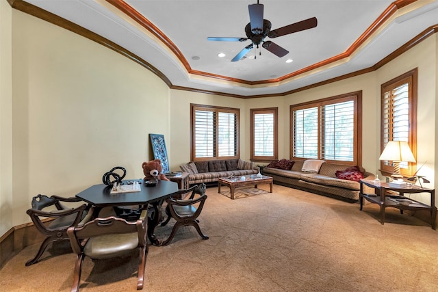 living room featuring ceiling fan, a raised ceiling, carpet flooring, and crown molding