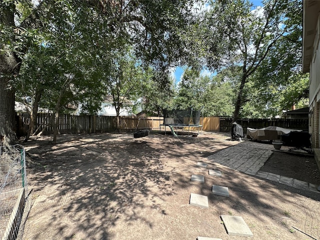 view of yard with a patio and a trampoline