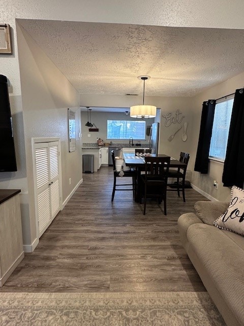 dining room with sink, wood-type flooring, and a textured ceiling