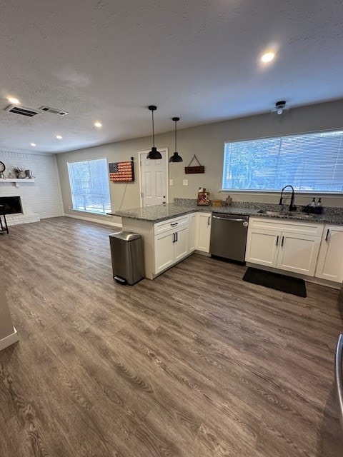 kitchen with a wealth of natural light, stainless steel dishwasher, hanging light fixtures, and white cabinets