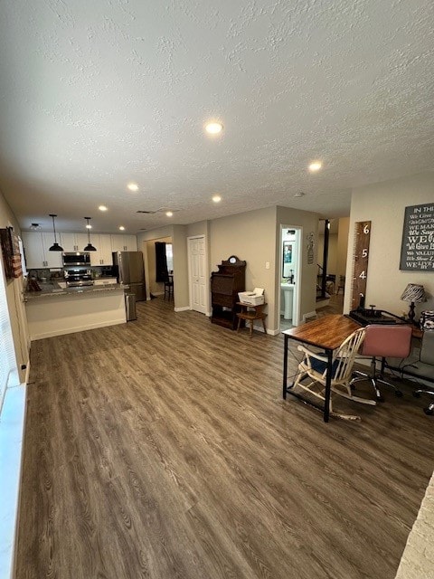 living room featuring dark wood-type flooring and a textured ceiling