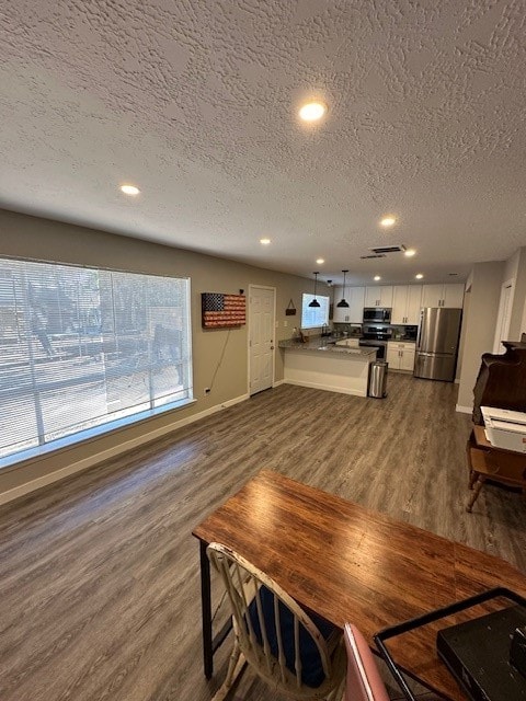 dining area featuring a textured ceiling and dark hardwood / wood-style floors