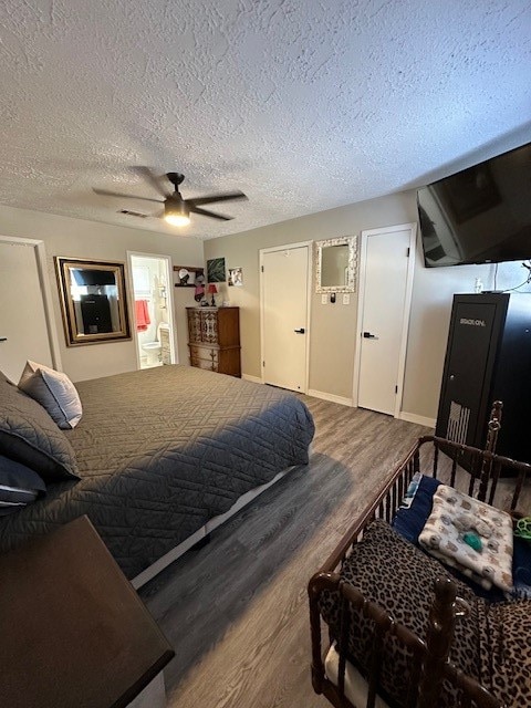 bedroom with connected bathroom, a textured ceiling, hardwood / wood-style flooring, and ceiling fan