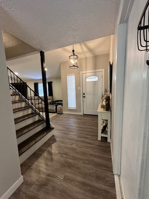 foyer featuring dark hardwood / wood-style floors and a textured ceiling