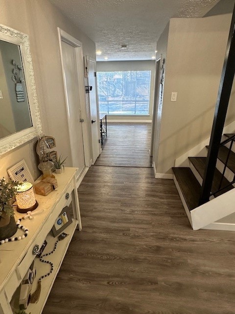 hallway with dark wood-type flooring and a textured ceiling