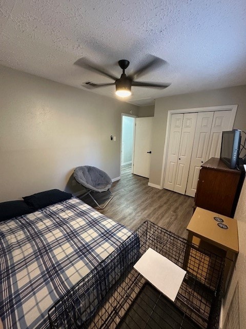 bedroom with ceiling fan, dark hardwood / wood-style floors, a closet, and a textured ceiling