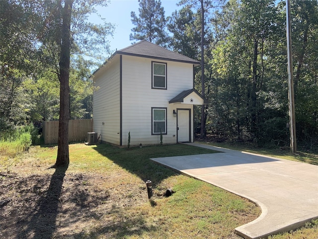 view of front of property featuring central AC, a front yard, and a garage