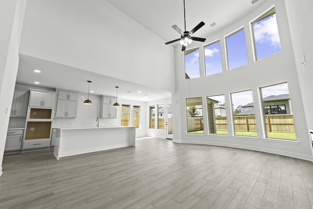 unfurnished living room with ceiling fan and wood-type flooring