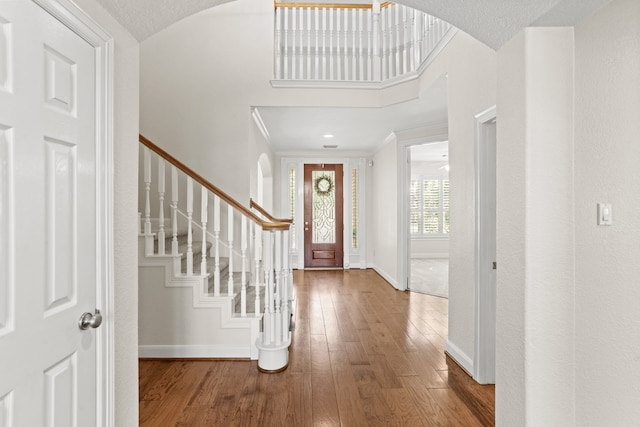 foyer entrance with wood-type flooring and crown molding