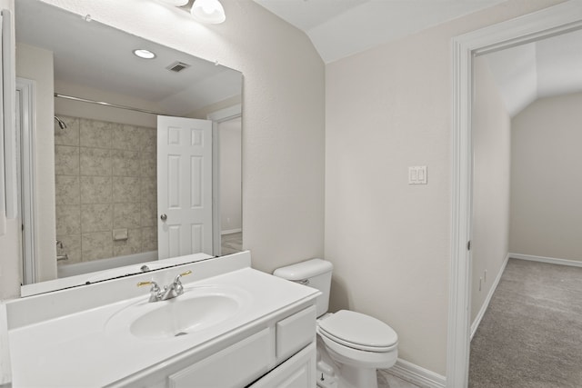 full bathroom featuring vaulted ceiling, tiled shower / bath, vanity, and toilet