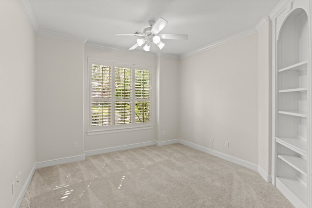 empty room featuring ceiling fan, light colored carpet, and ornamental molding