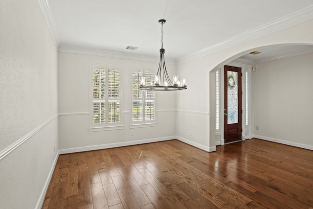 spare room with crown molding, dark hardwood / wood-style flooring, and a chandelier