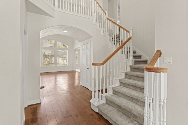 foyer entrance featuring dark hardwood / wood-style flooring and a high ceiling