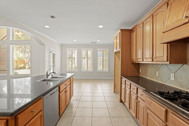 kitchen featuring tasteful backsplash, dishwasher, dark stone counters, ornamental molding, and sink