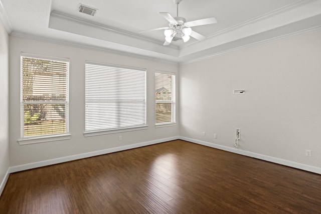 empty room featuring ornamental molding, ceiling fan, a raised ceiling, and dark hardwood / wood-style floors