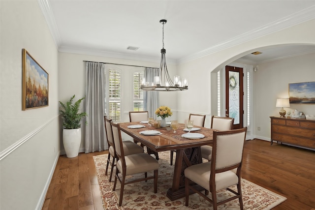 dining space with a chandelier, hardwood / wood-style floors, and crown molding