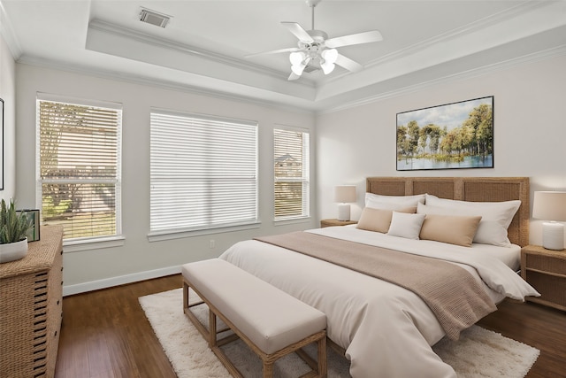 bedroom with crown molding, a tray ceiling, dark hardwood / wood-style flooring, and ceiling fan