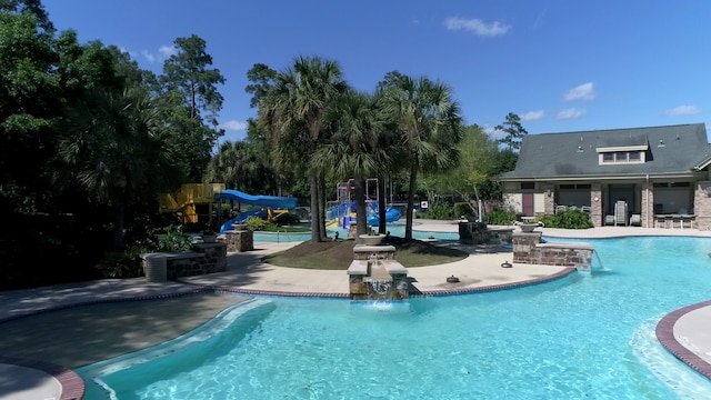 view of swimming pool featuring a playground and a patio