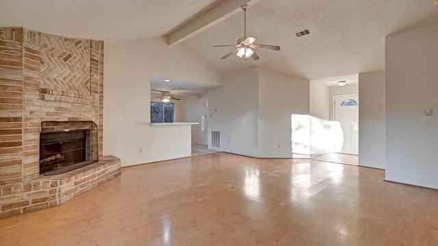 unfurnished living room featuring a fireplace, hardwood / wood-style floors, ceiling fan, and beamed ceiling