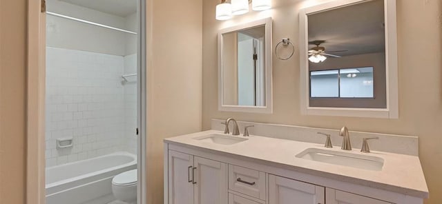 full bathroom featuring ceiling fan, tiled shower / bath, vanity, and toilet