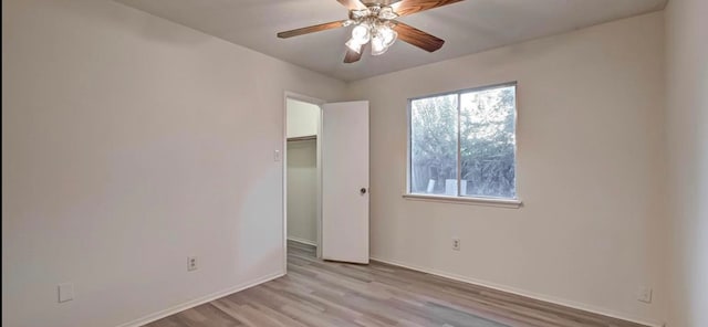 unfurnished bedroom with ceiling fan, light wood-type flooring, and a closet