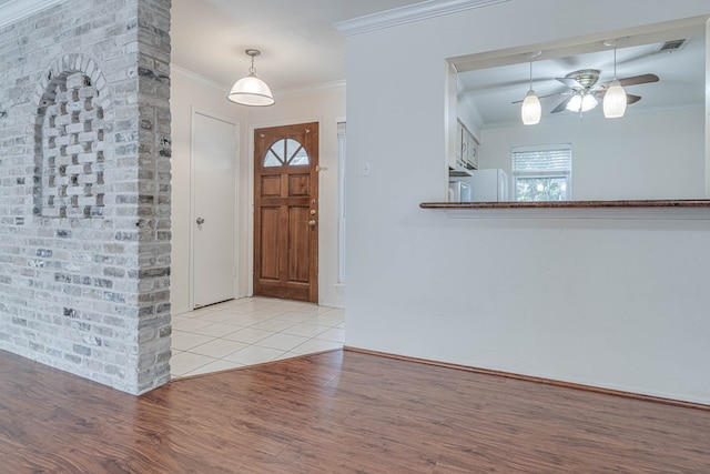 entrance foyer featuring light hardwood / wood-style flooring, ceiling fan, and ornamental molding