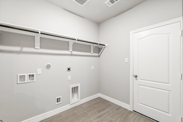 washroom featuring washer hookup, gas dryer hookup, light hardwood / wood-style floors, and electric dryer hookup