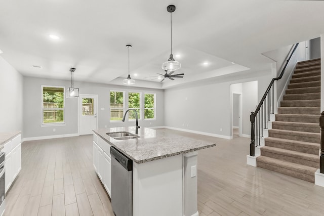 kitchen featuring stainless steel dishwasher, sink, white cabinets, and plenty of natural light