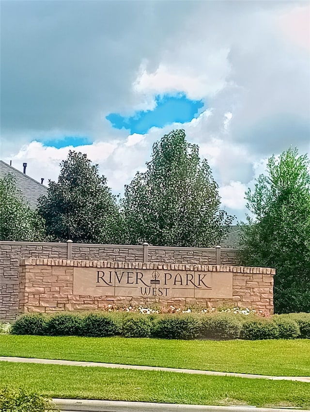 community / neighborhood sign featuring a lawn