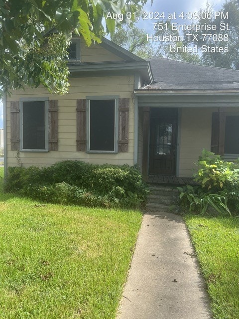 doorway to property featuring a porch and a yard