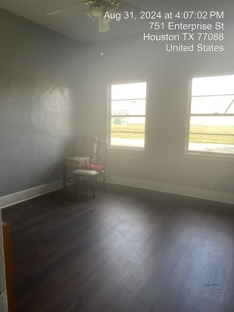 empty room with ceiling fan and dark hardwood / wood-style flooring