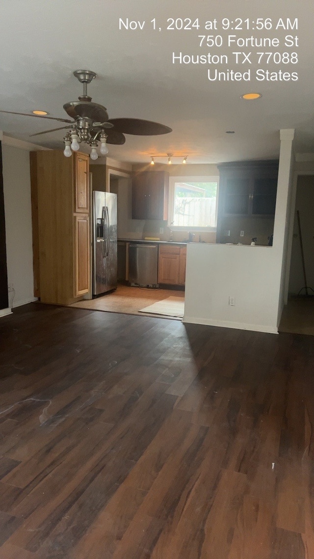 kitchen with appliances with stainless steel finishes, ceiling fan, and dark hardwood / wood-style flooring