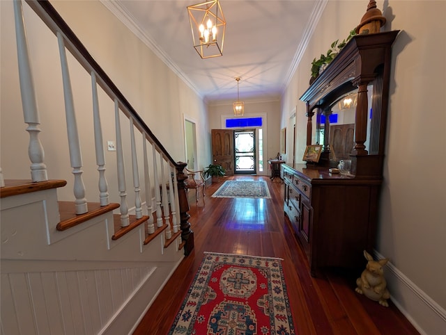 entrance foyer featuring crown molding, dark hardwood / wood-style flooring, and a chandelier