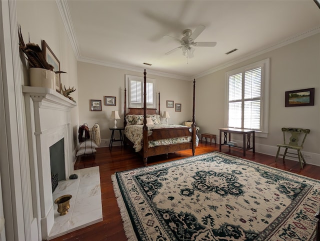 bedroom with a premium fireplace, ceiling fan, dark hardwood / wood-style floors, and ornamental molding