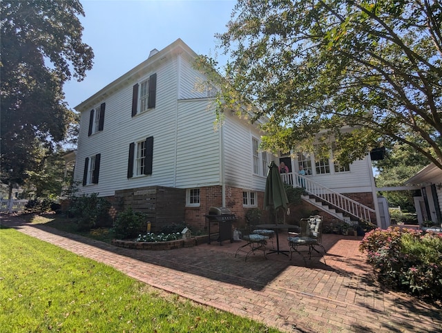 back of house featuring a patio and a lawn