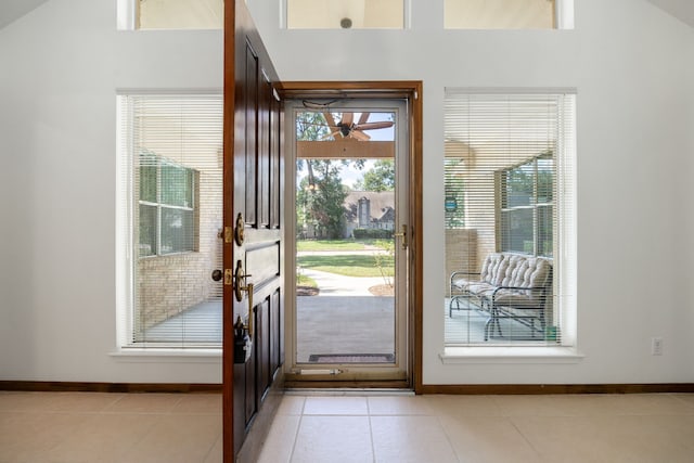 doorway to outside with vaulted ceiling and light tile patterned floors