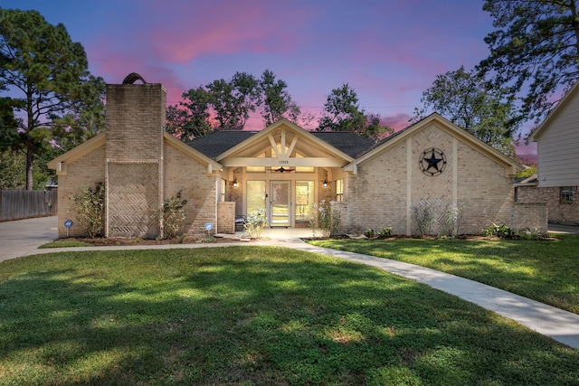 view of front facade featuring ceiling fan and a yard