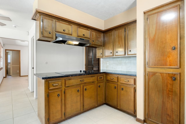 kitchen featuring a textured ceiling, light tile patterned flooring, backsplash, black electric cooktop, and ceiling fan