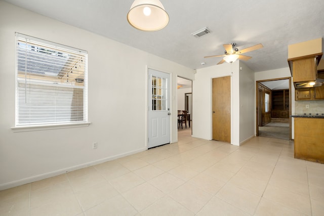 unfurnished room with light tile patterned floors, ceiling fan, and a healthy amount of sunlight