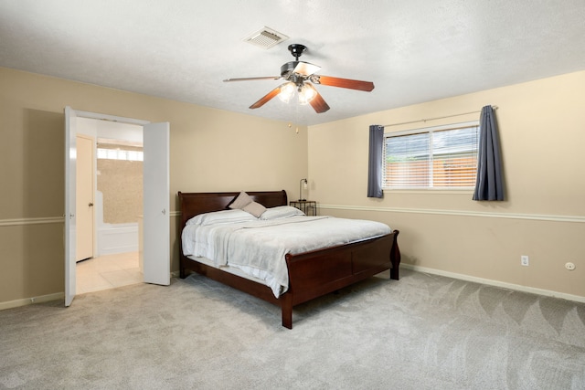 bedroom featuring connected bathroom, ceiling fan, and light colored carpet