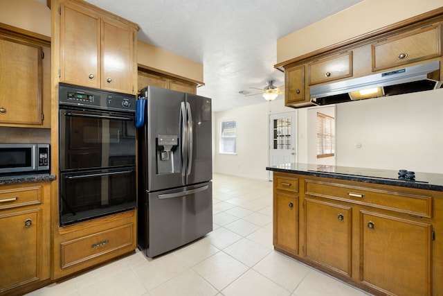 kitchen with ceiling fan, light tile patterned floors, dark stone countertops, and black appliances