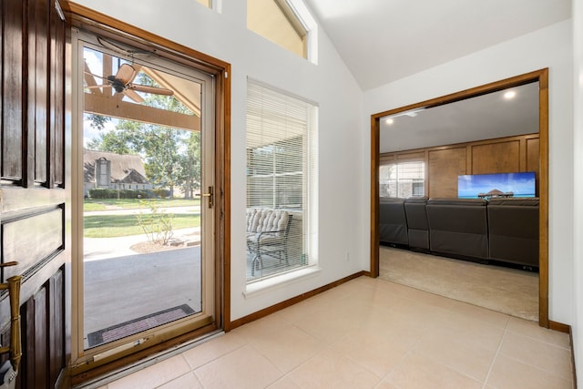 doorway featuring vaulted ceiling, ceiling fan, and light tile patterned floors