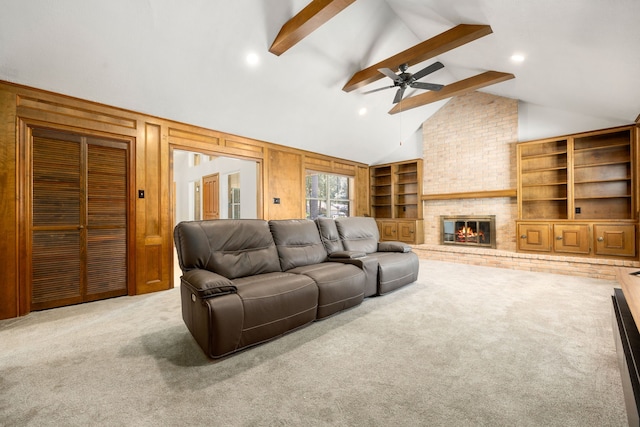 living room featuring a brick fireplace, beamed ceiling, ceiling fan, carpet, and wooden walls