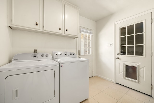 washroom with cabinets, light tile patterned floors, and washer and dryer