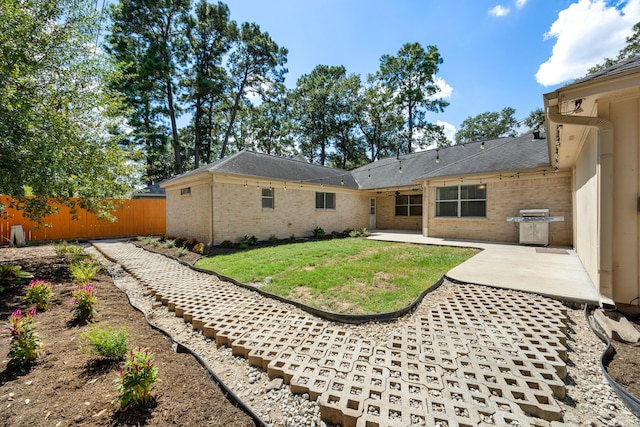 rear view of house featuring a lawn and a patio area